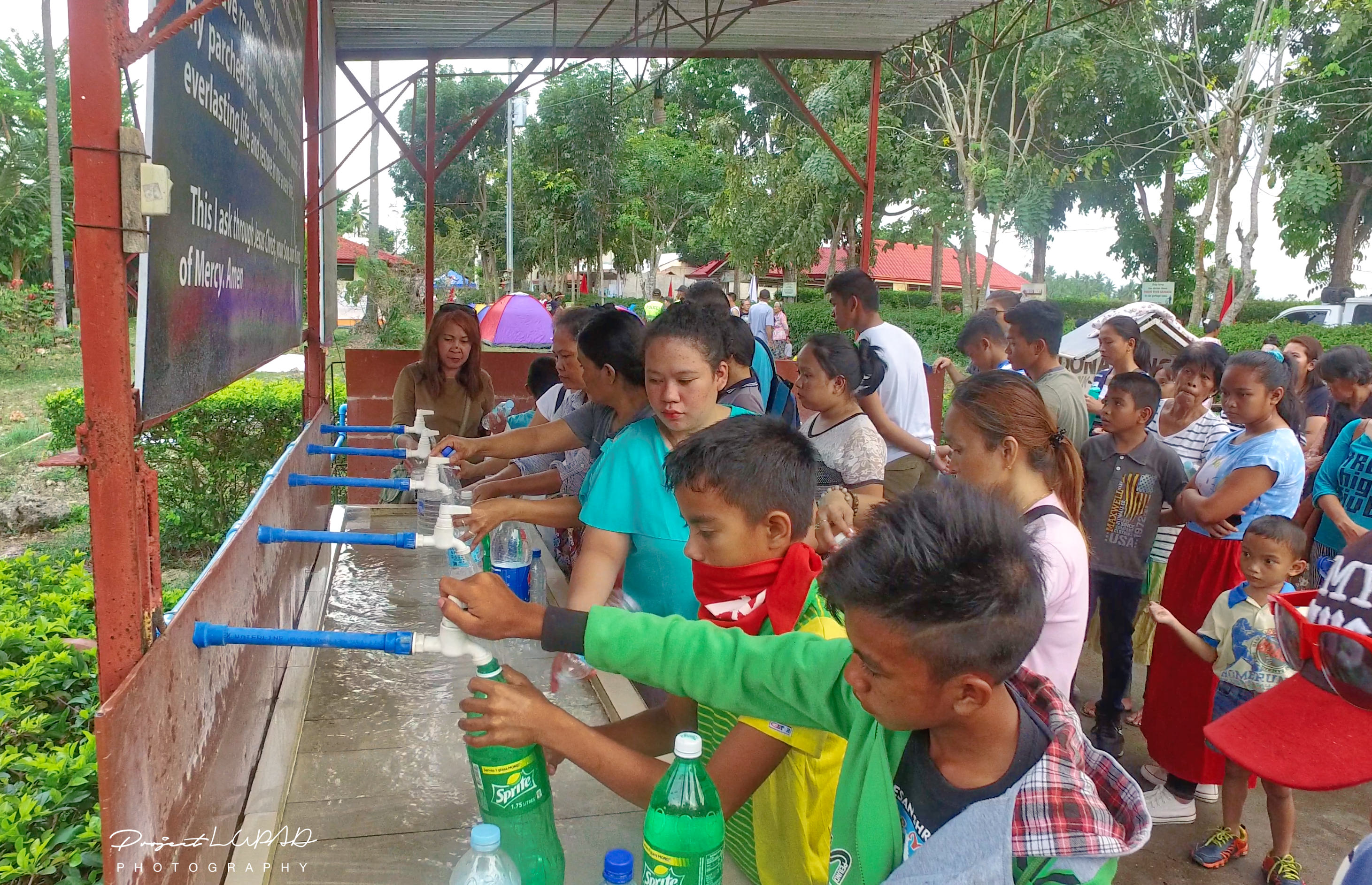 Pilgrims drawing out Healing Water.